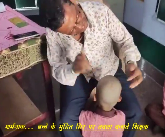 Teacher plays tabla on childs shaved head